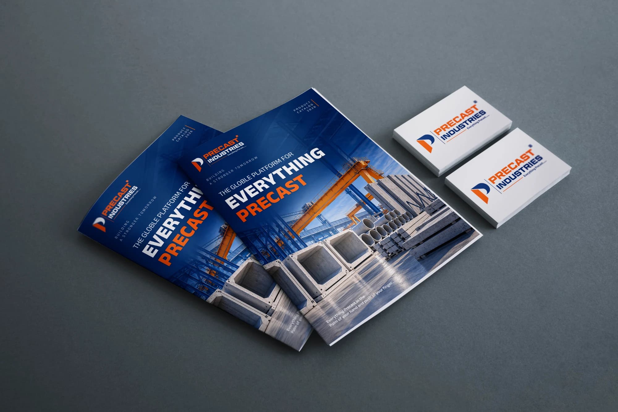 The Precast Industries 2026 product catalog and business cards laid out on a desk